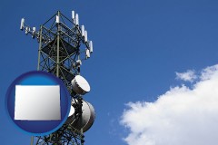 wyoming map icon and a telecommunications tower, with blue sky background